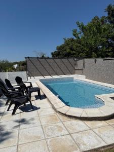 a swimming pool with two lounge chairs next to it at Tres Soles in Salsipuedes