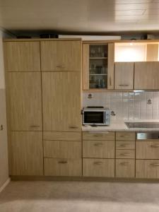 a kitchen with wooden cabinets and a microwave at Fewo EifelLenz in Hellenthal