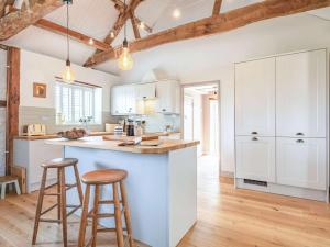 a kitchen with white cabinets and bar stools at 3 Bed in Beeston 88223 in Beeston +14 photos