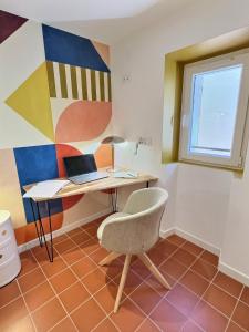 a room with a desk and a chair and a laptop at Le chateau de ma mère- climatisé -duplex- 4 personnes in Aubagne +16 photos