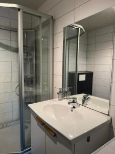 a white bathroom with a sink and a shower at Aurora view apartment III - close to everything in Tromsø +12 photos