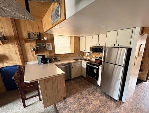 a kitchen with white cabinets and a stainless steel refrigerator at Summit House East 1 Bed Loft 2 Bath SHMB in Wheeler Junction