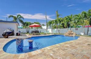 a swimming pool with a table and a red umbrella at Aquaria in Fort Lauderdale