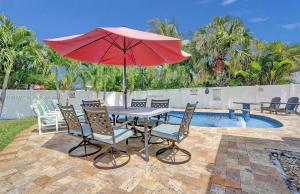 a table and chairs with an umbrella next to a pool at Aquaria in Fort Lauderdale