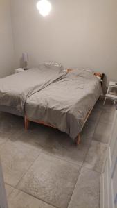 a bed in a bedroom with a tiled floor at Skutviken in Henån