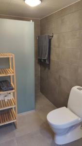 a bathroom with a toilet and a towel rack at Skutviken in Henån