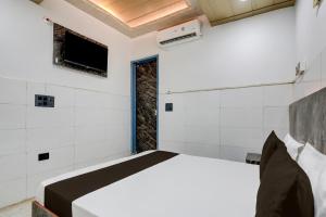 a bedroom with a bed and a tv on the wall at Hotel O Revive Inn in New Delhi