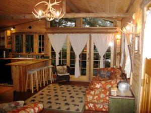 een woonkamer met een bank en een keuken bij All Season Romantic One-Room Cabin on Moody Pond, in Upstate New York in Saranac Lake