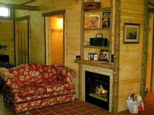 een woonkamer met een bank en een open haard bij All Season Romantic One-Room Cabin on Moody Pond, in Upstate New York in Saranac Lake +21 foto's