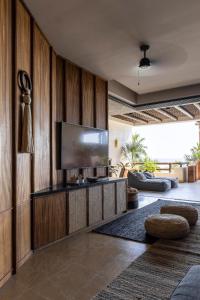 a living room with a tv on a wooden wall at Los Veneros Punta de Mita - Pacific Tower in Punta Mita
