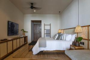 a bedroom with a large white bed and a couch at Los Veneros Punta de Mita - Pacific Tower in Punta Mita +6 photos