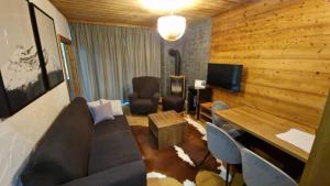 a living room with a couch and a table and a television at Apartment ABAKUS with jacuzzi & sauna in Demanovska Dolina