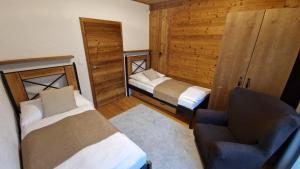 a room with two beds and a chair and a couch at Apartment ABAKUS with jacuzzi & sauna in Demanovska Dolina