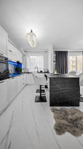a white kitchen with a desk and a sink at RT Luxury Royal Residence in Braşov