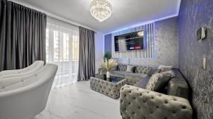 a living room with a couch and a tv at RT Luxury Royal Residence in Braşov