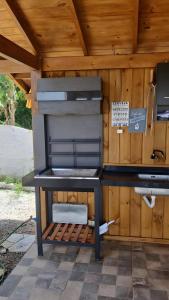 a barbecue grill sitting under a wooden roof at Pereira Sell Pousada in Garopaba
