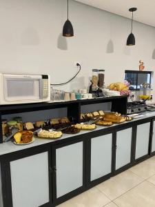 a kitchen with a counter with food on it at Hotel Sol Nascente in Assaí +27 photos
