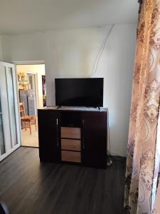 een woonkamer met een flatscreen-tv op een kast bij Acasă la Elias in Breb