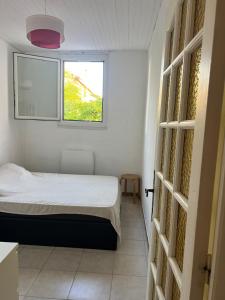 une petite chambre avec un lit et une fenêtre dans l'établissement Chez Theo, à Marseille