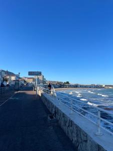 une personne marchant sur un trottoir à côté de la plage dans l'établissement Chez Theo, à Marseille