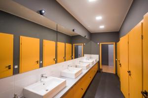 a bathroom with four sinks and yellow doors at Friday Hostel in Odesa +44 photos