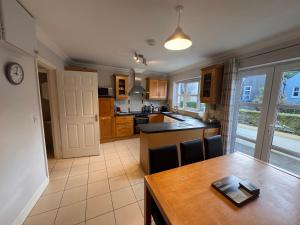 a kitchen with a wooden table and a dining room at Modern Home in the Heart of Rosscarbery Village in Rosscarbery