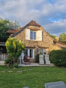 una casa de piedra con sillas y un patio en Le Clos Des Etoiles, en Le Bugue