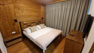 a bedroom with a bed in a wooden room at Apartment ABAKUS with jacuzzi & sauna in Demanovska Dolina