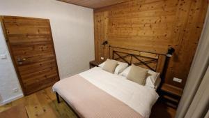 a bedroom with a white bed and a wooden wall at Apartment ABAKUS with jacuzzi & sauna in Demanovska Dolina +39 photos
