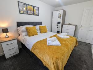 a bedroom with a bed with two towels on it at Modern Four Bedroom House near Attractions, Stadium, Town Centre, Parks and Lake - Sky n Netflix - Convenient Transport in Burnley
