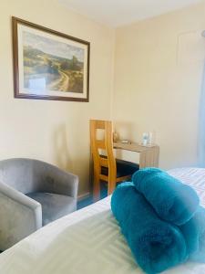 a bedroom with a bed with a blue pillow on it at Lincoln Cathedral Retreat in Scampton