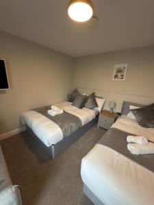 a bedroom with two beds and a lamp in it at Modern Studio London Near Hospital in Thornton Heath