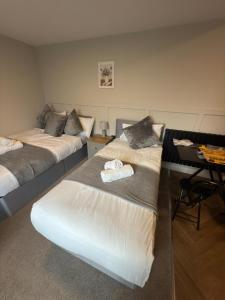 a room with two beds and a desk in it at Modern Studio London Near Hospital in Thornton Heath