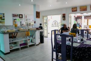 two people sitting at a table in a restaurant at Pousada Vó Irene in Itacuruçá