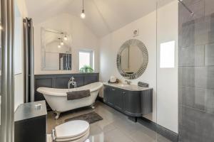 a bathroom with a tub and a toilet and a sink at 3 Bed in Mealsgate oc-e33626 in Mealsgate +15 photos