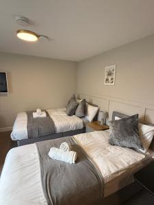 two beds in a hotel room with towels on them at Modern Studio London Near Hospital in Thornton Heath