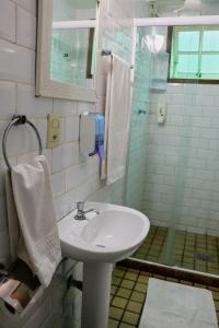 a bathroom with a sink and a shower at Pousada Vó Irene in Itacuruçá +39 photos