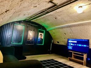 a living room with a tv and green lights at L'ARCADE SECRETE Appartement climatisé, Jacuzzi, Borne d'arcade Bordeaux centre in Bordeaux