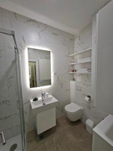 a bathroom with a toilet and a sink and a mirror at Apartman REINA HOME in Prijedor +17 photos