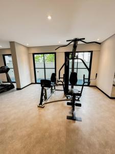 uma academia com equipamentos cardiovasculares em uma sala com janelas em !Novinho! Apê Elamor - Brooklin - SP em São Paulo