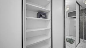 a walk in closet with white shelves and a mirror at RT Luxury Royal Residence in Braşov +32 photos