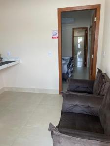 a living room with a couch and a hallway at Apartamento solteiro sinop 9 in Sinop