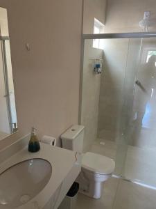 a bathroom with a toilet and a sink and a shower at Apartamento solteiro sinop 9 in Sinop