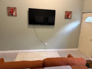 a living room with a couch and a flat screen tv on the wall at Carolus Suites in Gros Islet