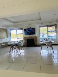 a large room with tables and chairs and windows at Omaha Luxury B&B & SPA in Mthatha