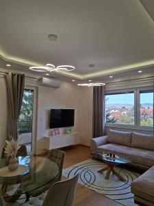 a living room with a couch and a table at Apartman REINA HOME in Prijedor