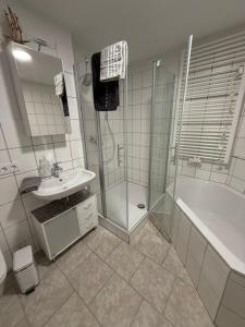 a bathroom with a shower and a sink and a tub at Panorama-180-Grad in Kitzingen