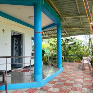 a view of the front porch of a house with blue columns at Wild Nest Kotagiri in Kotagiri +25 photos
