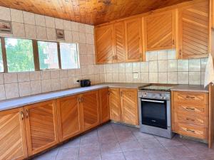 a kitchen with wooden cabinets and a stove at Field's End in Howick +6 photos