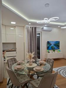 a dining room with a glass table and chairs at Apartman REINA HOME in Prijedor
